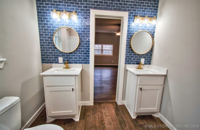 bathroom with vanity, toilet, wood-type flooring, and tile walls