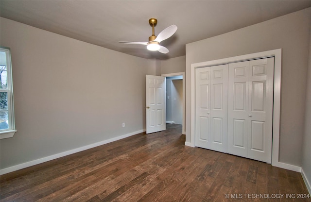 unfurnished bedroom with a closet, ceiling fan, and dark hardwood / wood-style flooring