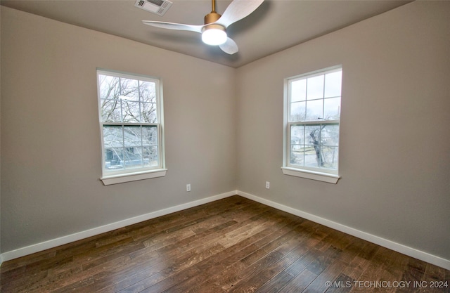 empty room featuring ceiling fan and dark hardwood / wood-style flooring