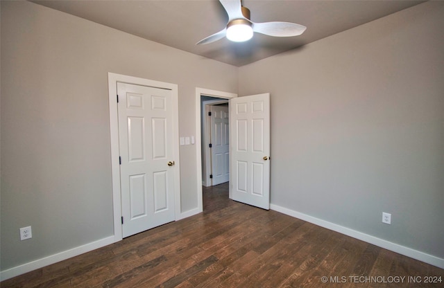 unfurnished bedroom featuring ceiling fan and dark hardwood / wood-style flooring