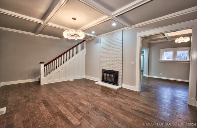 unfurnished living room featuring a notable chandelier, coffered ceiling, dark hardwood / wood-style flooring, and a fireplace