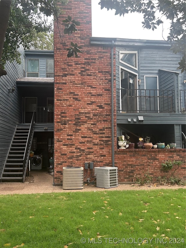 view of property exterior with central AC and a lawn