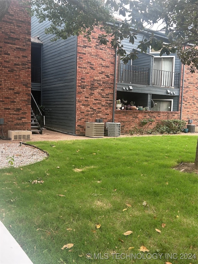 view of yard with cooling unit and a balcony