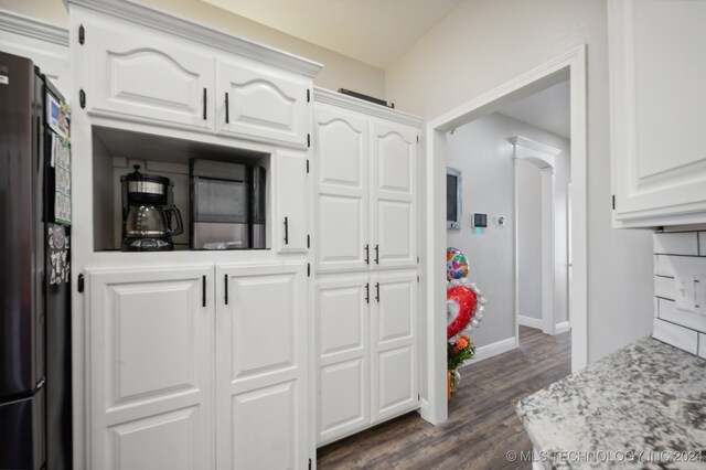 kitchen with black appliances, white cabinetry, backsplash, and dark hardwood / wood-style floors