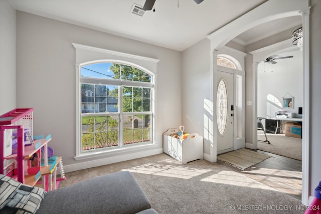 living room featuring dark hardwood / wood-style flooring, ornate columns, ceiling fan, and crown molding