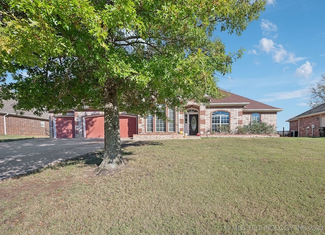 view of front of property featuring a front yard and a garage