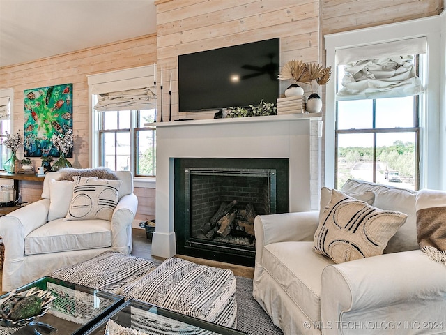 living room with wood walls, wood-type flooring, and a wealth of natural light