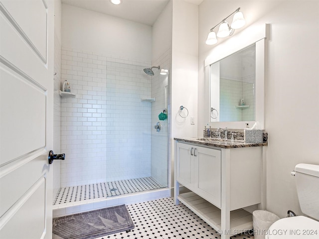 bathroom featuring vanity, toilet, and tiled shower