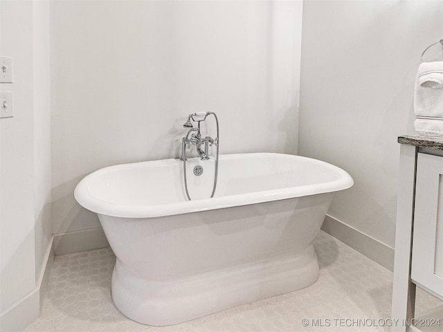 bathroom with vanity, a tub, and tile patterned flooring