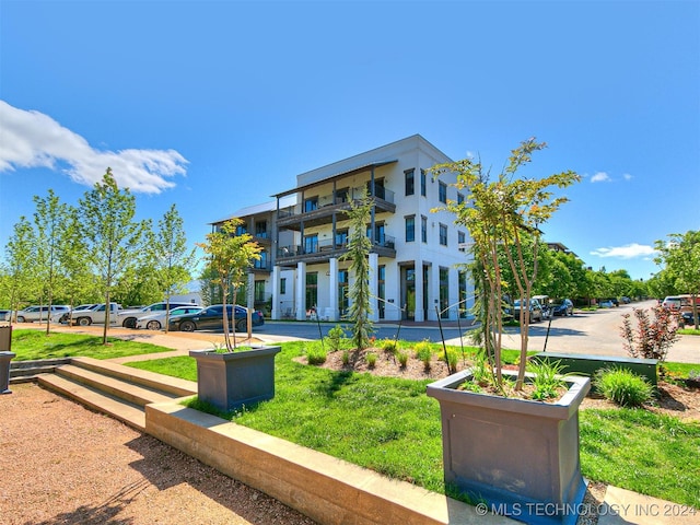 exterior space with a front yard and a balcony