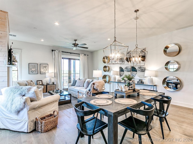 dining area featuring hardwood / wood-style flooring and ceiling fan with notable chandelier