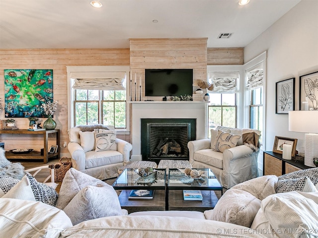 living room with hardwood / wood-style flooring and wood walls