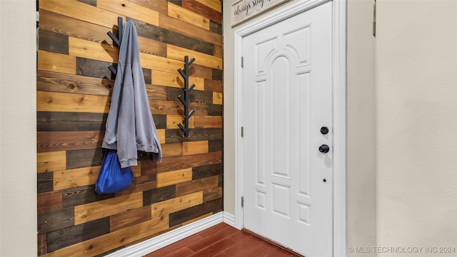 interior space featuring dark wood-type flooring and wooden walls