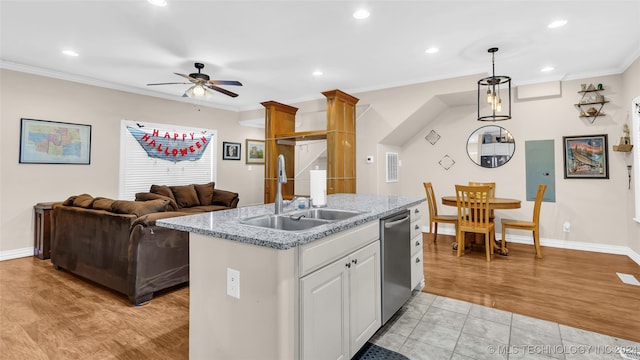 kitchen with a kitchen island with sink, sink, decorative light fixtures, light wood-type flooring, and white cabinetry