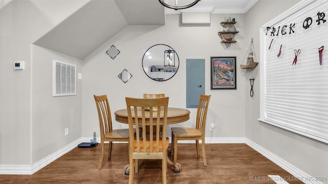 dining space featuring dark wood-type flooring, crown molding, vaulted ceiling, and electric panel