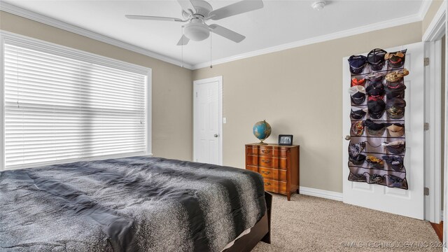 carpeted bedroom featuring ornamental molding and ceiling fan