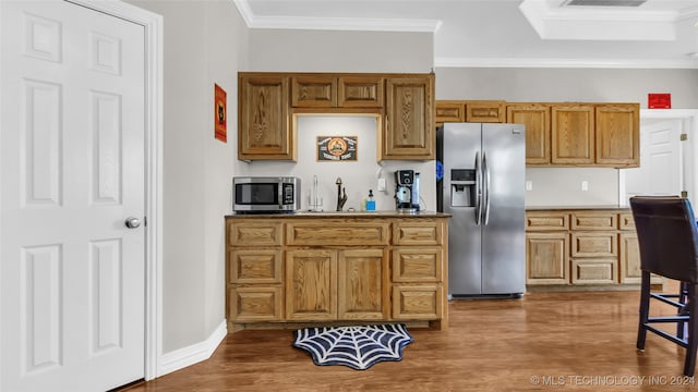 kitchen featuring crown molding, appliances with stainless steel finishes, and dark hardwood / wood-style floors