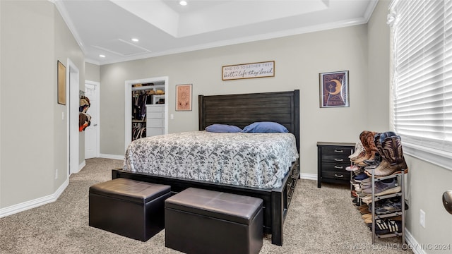 bedroom featuring light carpet, crown molding, a closet, and a walk in closet