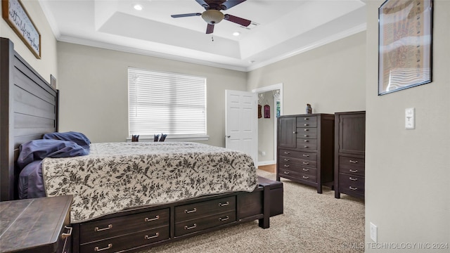 carpeted bedroom featuring ornamental molding, a raised ceiling, and ceiling fan