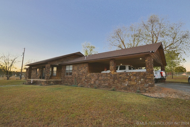 property exterior at dusk featuring a lawn and a carport