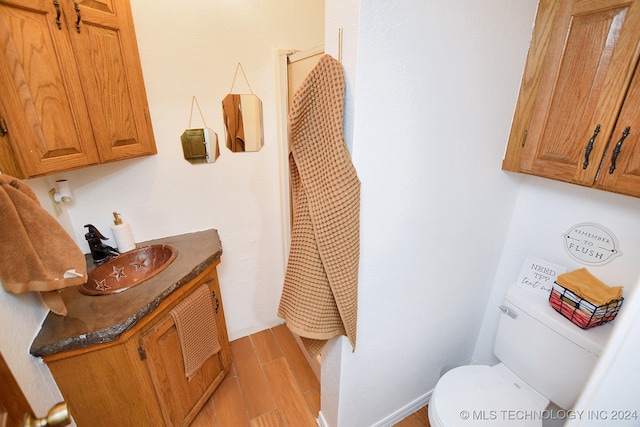 bathroom featuring vanity, hardwood / wood-style flooring, and toilet