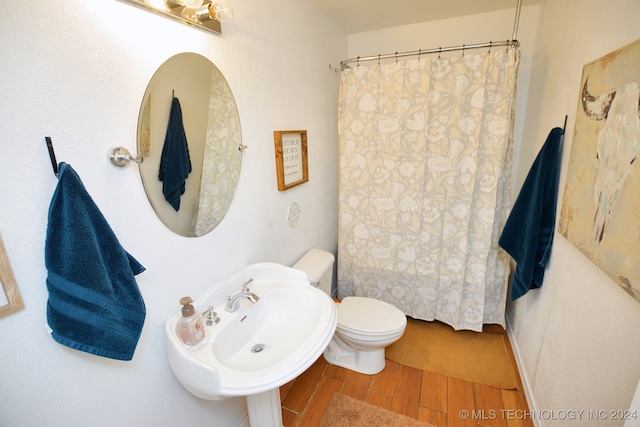 bathroom with toilet, walk in shower, hardwood / wood-style flooring, and sink