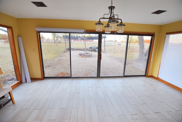 unfurnished sunroom featuring a notable chandelier