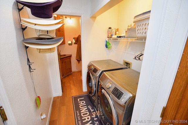 washroom with washer and clothes dryer and light wood-type flooring