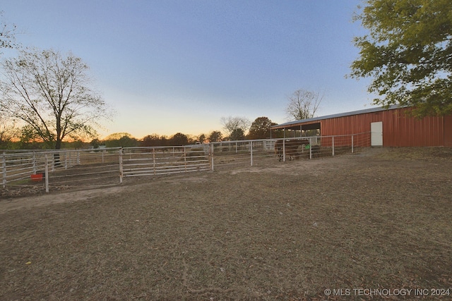 yard at dusk with a rural view and an outbuilding