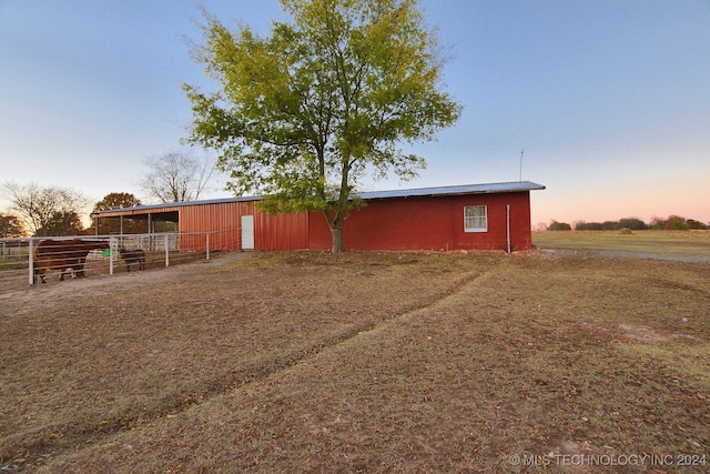 yard at dusk featuring an outbuilding