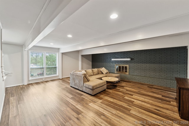 unfurnished living room featuring hardwood / wood-style floors, a brick fireplace, and brick wall