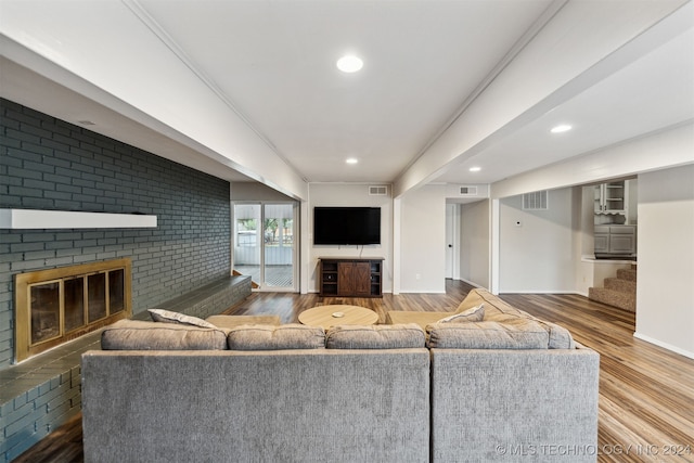 living room featuring crown molding and a brick fireplace