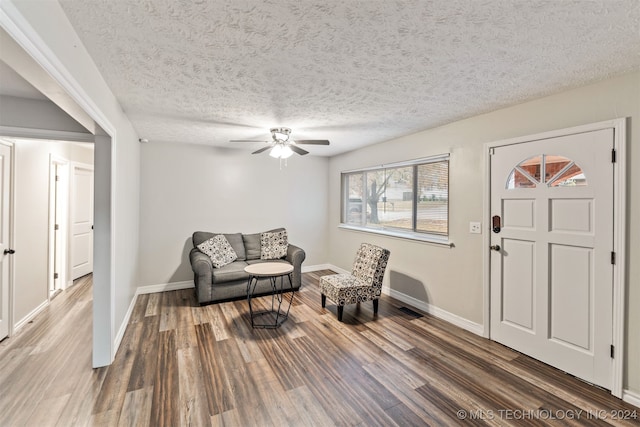 sitting room featuring a textured ceiling, dark hardwood / wood-style floors, and ceiling fan