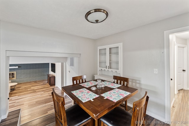 dining room featuring a fireplace and hardwood / wood-style flooring