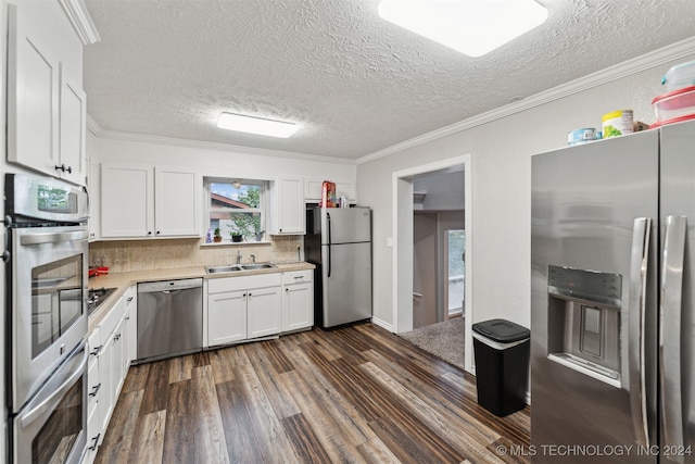 kitchen featuring white cabinets, sink, crown molding, decorative backsplash, and stainless steel appliances