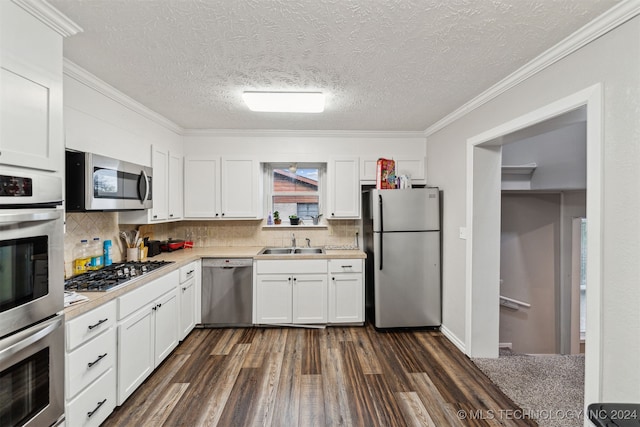 kitchen featuring white cabinets, appliances with stainless steel finishes, tasteful backsplash, and sink