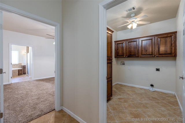 clothes washing area featuring a ceiling fan, cabinet space, electric dryer hookup, light tile patterned flooring, and baseboards