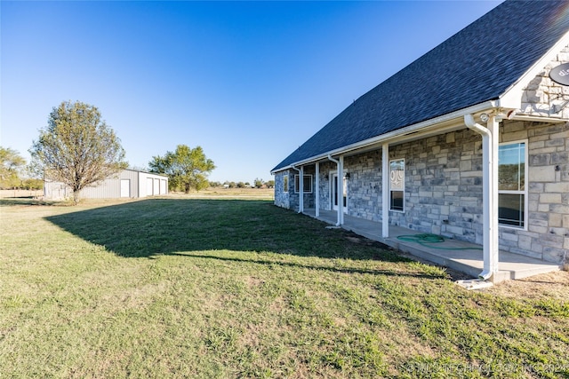 view of grassy yard with an outbuilding