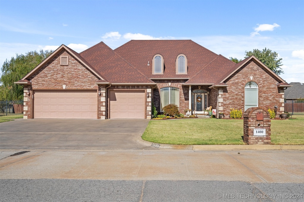 view of property featuring a front yard and a garage