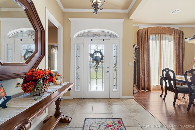 entryway featuring ornamental molding and light hardwood / wood-style flooring