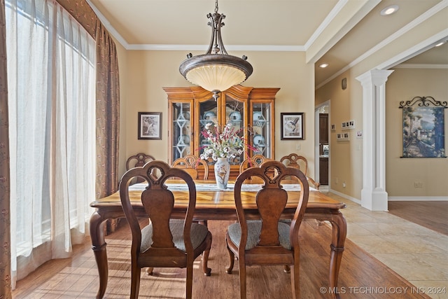 dining room with decorative columns, crown molding, and plenty of natural light