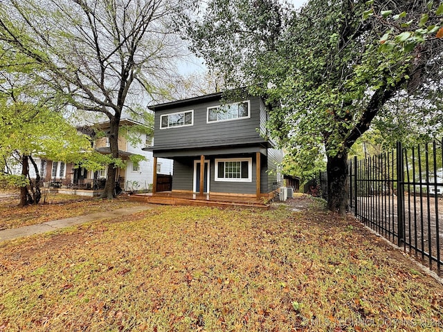 view of front of home with a front yard, central AC, and a porch