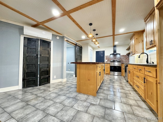 kitchen featuring tasteful backsplash, a barn door, pendant lighting, stainless steel range, and wall chimney exhaust hood