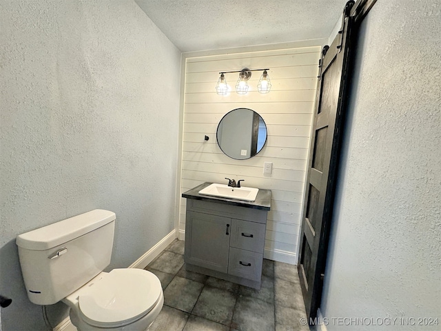 bathroom featuring tile patterned flooring, vanity, a textured ceiling, and toilet