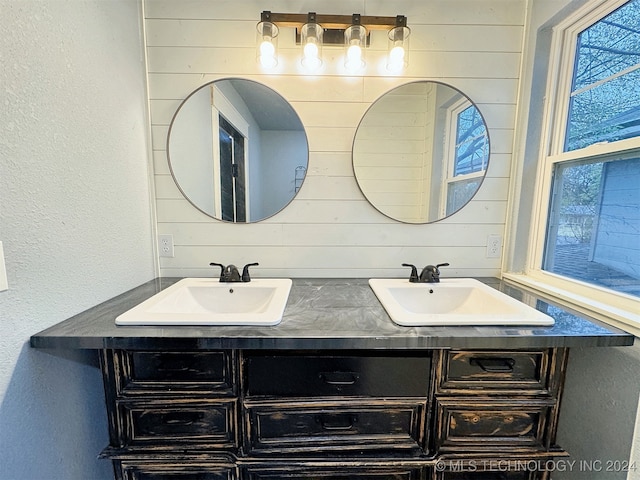 bathroom featuring wood walls and vanity