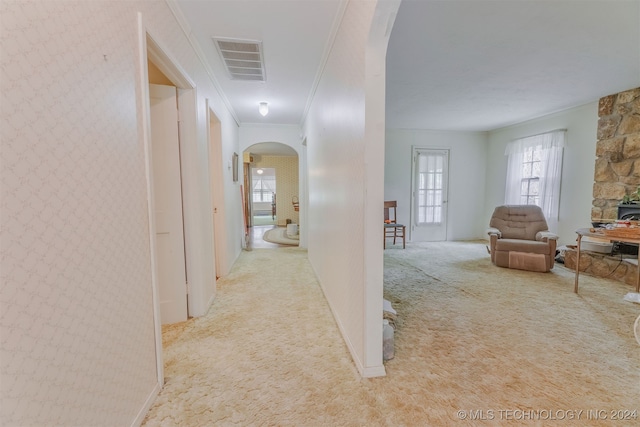 hallway featuring light carpet and ornamental molding