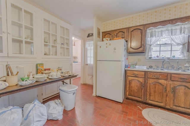 kitchen with crown molding, white fridge, and sink