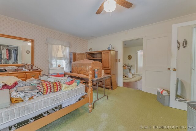 carpeted bedroom featuring ornamental molding and ceiling fan