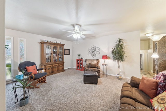 living room featuring carpet flooring, ceiling fan, and a fireplace