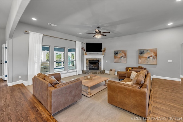living room with baseboards, a stone fireplace, a ceiling fan, recessed lighting, and wood finished floors
